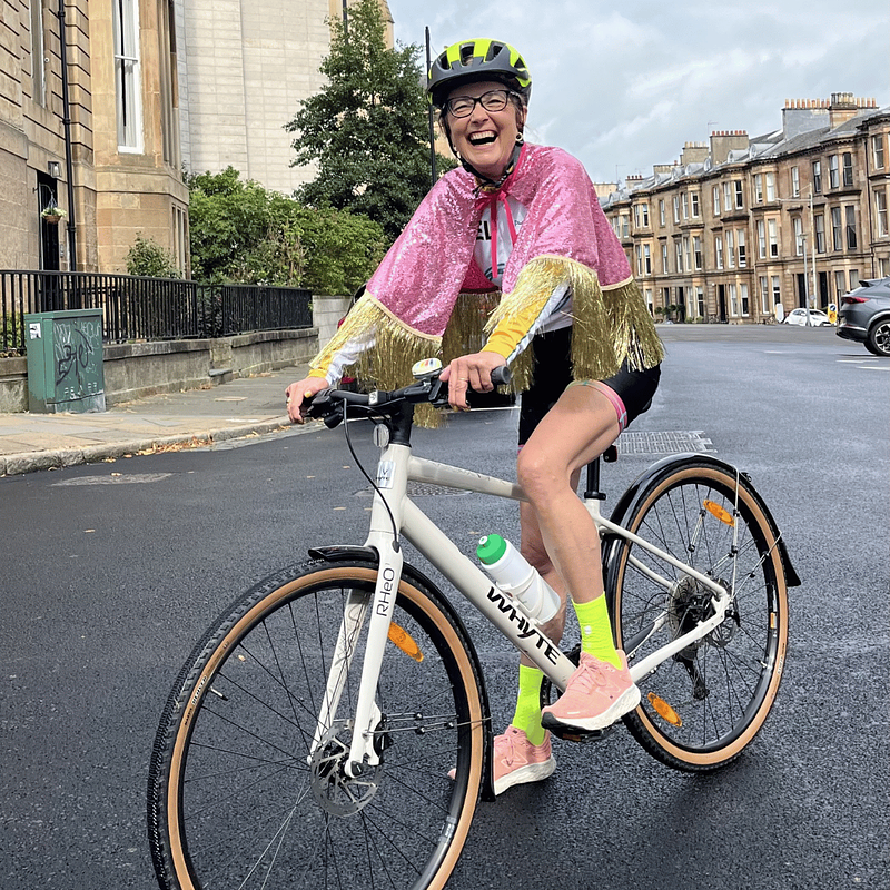 Mel cycling in glittery superhero cape