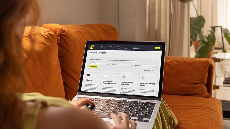 Person on laptop looking at Cancer Card Support Directory